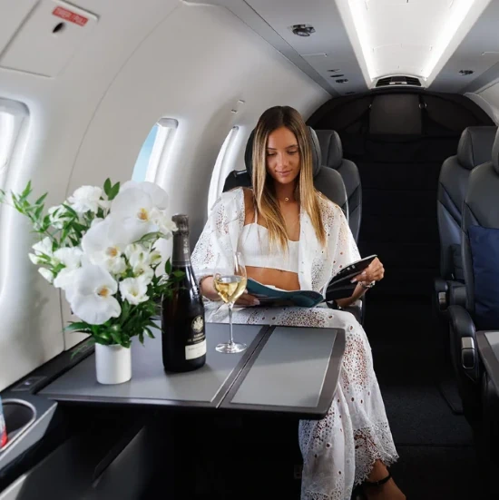 Passenger inside a St Barth Executive Pilatus cabin, reading Away Magazine